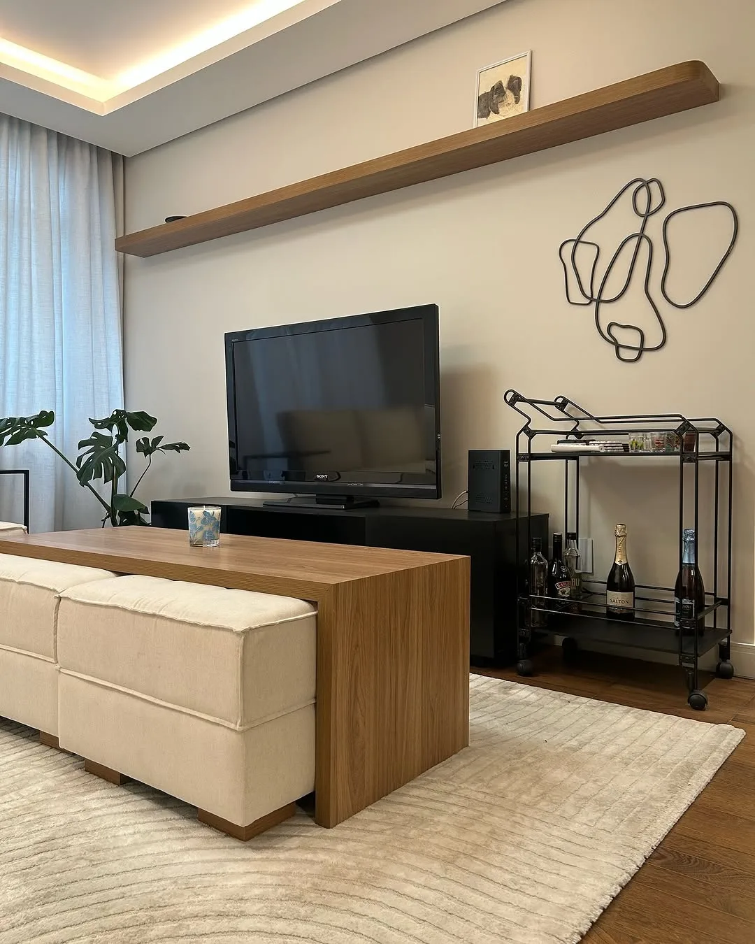 Estar com painel de TV, escultura de arame e carrinho de apoio