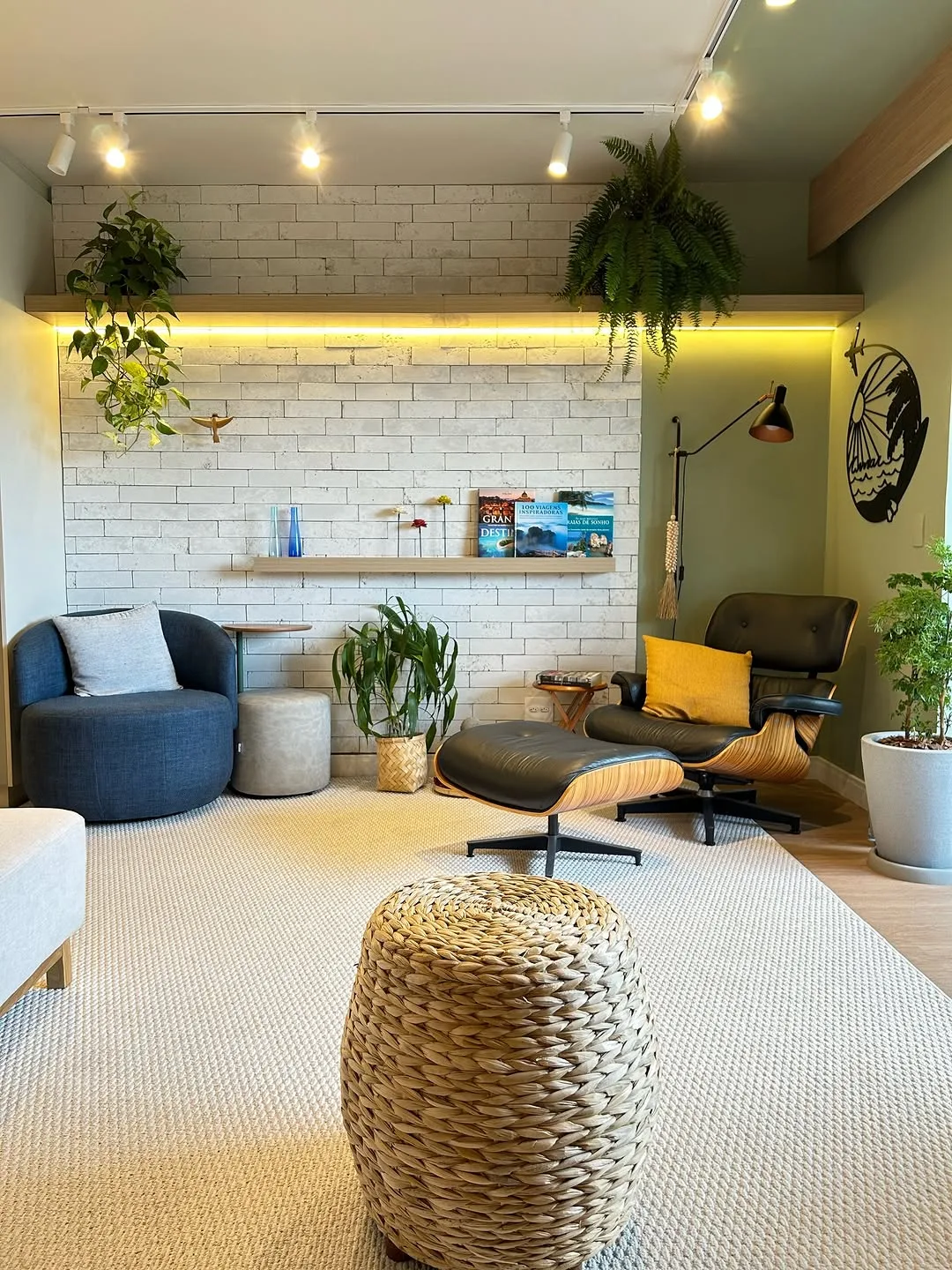 Estar integrado ao jantar, com tijolo branco, vegetação e luz em trilho