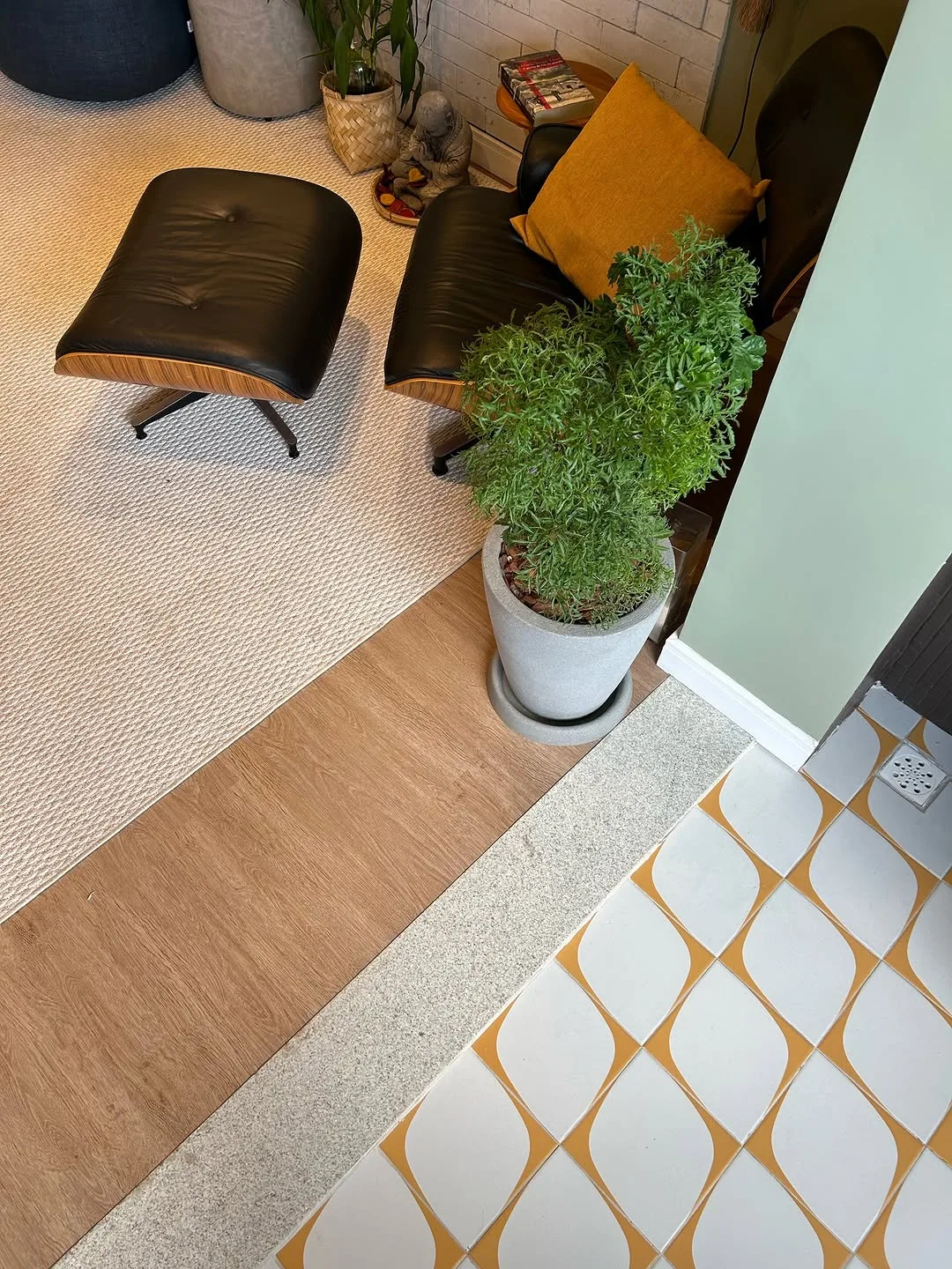 Mesa de madeira maciça com borda natural, poltronas e vegetação, sob trilho de luz
